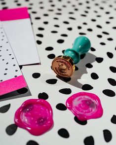 some pink and green wax on top of a polka dot table