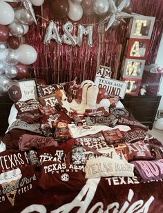 the bed is covered with texas themed sheets and pillowcases, along with balloons