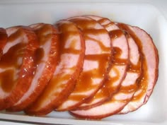 slices of ham with caramel sauce in a container