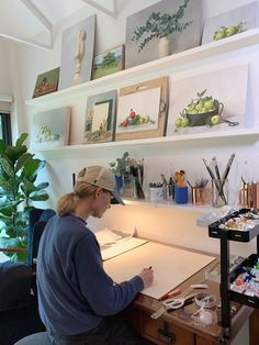 a woman sitting at a desk drawing on paper