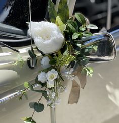 a white car decorated with flowers and greenery