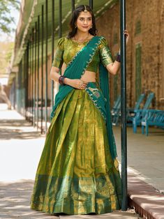 Introducing an exquisite masterpiece of traditional Indian attire: the green kanchipuram silk half saree lehenga with intricate zari weaving work. This lehenga is a stunning blend of rich heritage and contemporary style, crafted meticulously to enhance your elegance at any event. The fabric’s luxurious texture and the grandeur of the zari work reflect the impeccable craftsmanship of kanchipuram silk, known for its unparalleled quality and beauty. Accompanying this majestic lehenga is a green kan Blouse For Half Saree, South Lehenga, Traditional Dresses From Saree, Saree Look Traditional Wedding, South Indian Style Half Saree, Silk Saree Lehenga, Saree Ghagra, Saree Styles Wedding, Silk Half Saree Designs