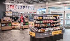 the inside of a grocery store with people shopping for groceries and other items on display