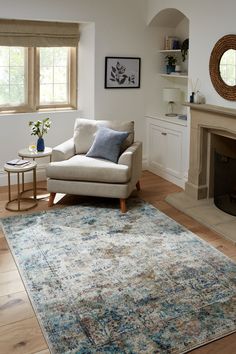 a living room with a couch, chair and fire place in it's center