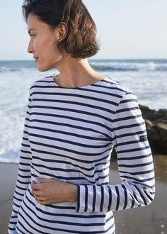 Cut in our best-selling soft cotton jersey, the MINQUIDAME is specifically designed for women with a round neck collar, fitted waistline, and long sleeves perfect for all-season wear. Other styles in this material include GALATHEE II with 3/4 sleeves, ETRILLE II with short sleeves, and MINQUIERS MODERNE in a boyfriend fit. Like all Saint James fabrics, our hospitality industry-endorsed light cotton is engineered to stand the test of time and of countless cold washes. For a more substantial, text Spring Cotton T-shirt With Striped Sleeves, Shirt With Long Sleeve, Nautical Cotton T-shirt For Summer, Saint James Striped Shirt, Spring Everyday T-shirt With Contrast Stripes, Nautical Style Cotton T-shirt With Short Sleeves, Breton Stripe Shirt, Striped Shirt Women, Classic Capsule Wardrobe