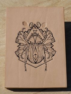 a drawing of a beetle on a piece of paper that is sitting on a table