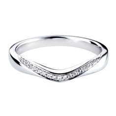 a white gold wedding band with diamonds on the sides and a curved design in the middle