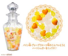 a glass bottle with candy in it next to a doily that has hearts on it