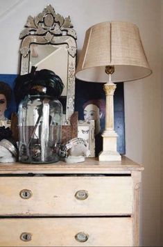 a dresser with a lamp, doll and other items on it