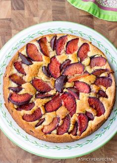 a cake with sliced strawberries is on a green and white plate