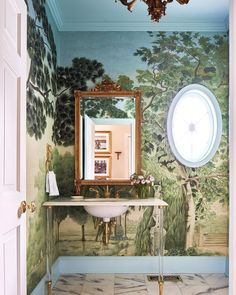 a bathroom with a mirror, sink and painting on the wall