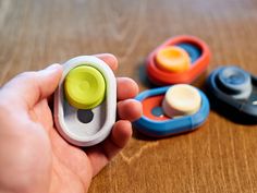 a hand holding a small toy in front of several other toys on a table top