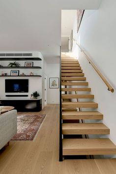 a living room filled with furniture and wooden stairs