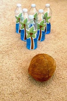 there is a coconut and six water bottles on the floor next to it, which are decorated with palm trees