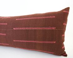 a brown pillow with pink lines on it