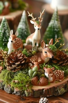 small deer figurines sitting on top of a tree stump surrounded by pine cones