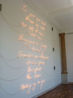 a white wall that has some writing on it and lights in the corner behind it