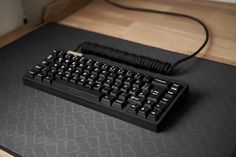 a black computer keyboard sitting on top of a desk next to a cordless mouse