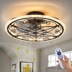 a person is holding a remote control in their hand while the ceiling light is on