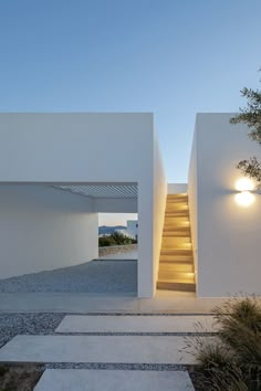 the stairs lead up to the upper level of this modern house, which has been designed in white