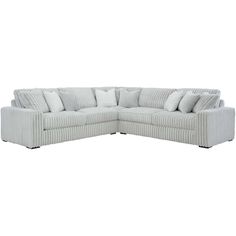 a white sectional couch with pillows on it's back and side facing each other