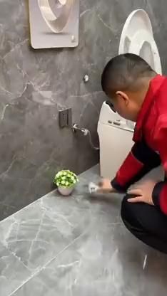 a man kneeling down in front of a toilet