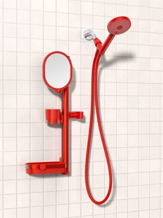 a red shower faucet and hand shower head in a white tiled bathroom with tile walls