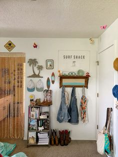 there is a surf shack with clothes hanging on the wall and other things in the room