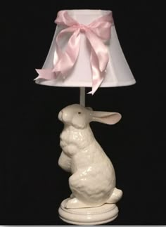 a white rabbit lamp with a pink bow on it's head