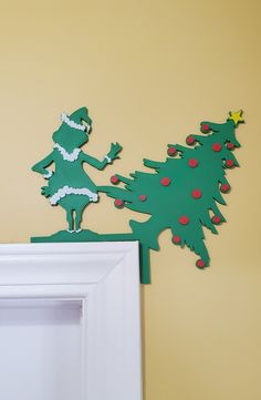 a wooden cutout of a christmas tree on top of a white frame