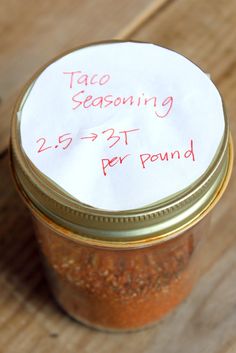 a jar filled with seasoning sitting on top of a wooden table