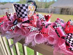 a close up of a wreath on a fence with pink and black decorations around it