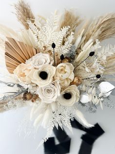 an arrangement of flowers and feathers on a white background