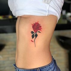 a woman's stomach with a rose tattoo on it