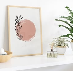 a white shelf topped with plants and vases next to a framed painting on the wall