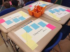 two tables with sticky notes on them in a classroom