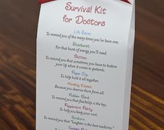 a paper sign that says survival kit for doctors hanging on a wooden table with a red ribbon around it