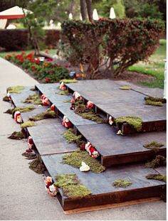 moss covered steps are lined up in the middle of a sidewalk with red and white flowers on them