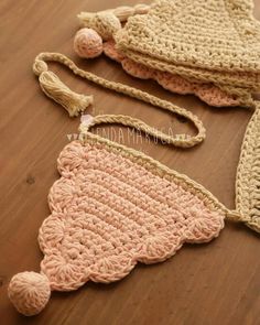 two crocheted purses sitting on top of a wooden table