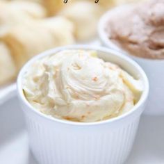 two cups filled with food sitting on top of a white table next to other foods