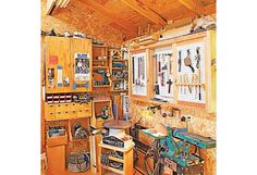 a workbench with many tools in it and lots of wood on the walls