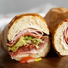 a cut in half sandwich sitting on top of a wooden cutting board