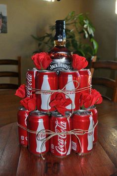 a stack of coca - cola cans sitting on top of each other with roses in them