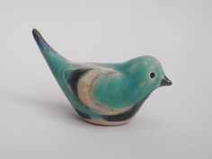 a ceramic bird sitting on top of a white table