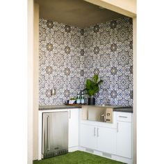 a kitchen with blue and white tiles on the wall, green grass in the floor