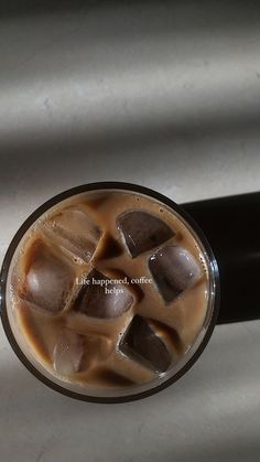 a drink with ice cubes in it sitting on a table