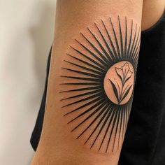 a woman's arm with a tattoo on it and a flower in the center