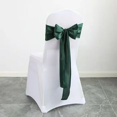 a white chair with a green bow tied to it's back on a tile floor