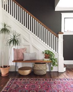 a living room with a couch, rug and stair case in front of the bannister