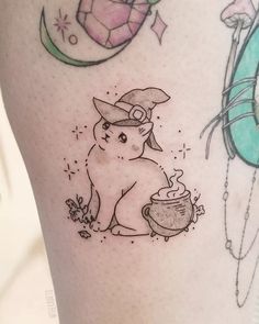 a tattoo on the leg of a woman with an image of a cat holding a teapot